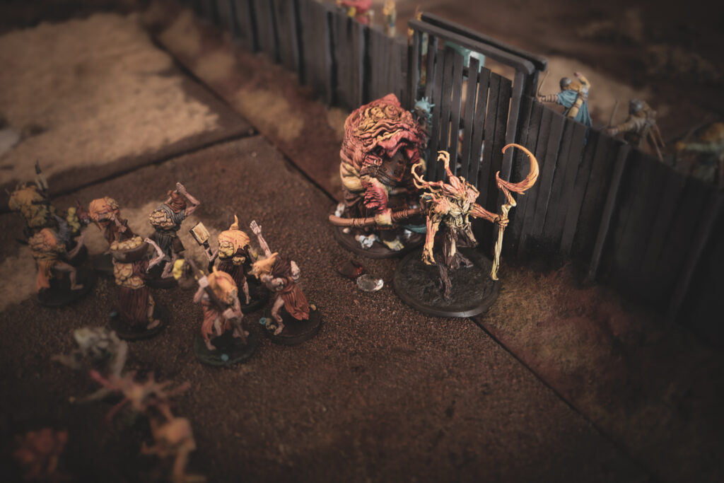 A Gnarl Host tries to tear down the gate of the fortified settlement.